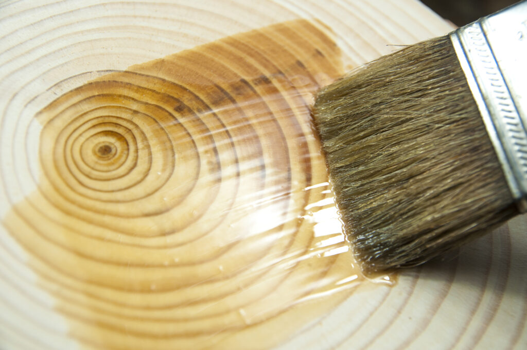oil coating cross cut tree with brush close up